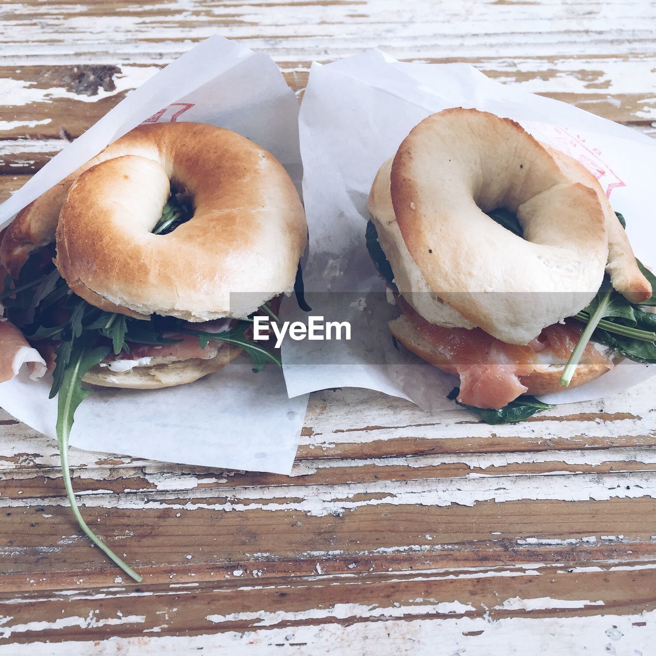 High angle view of meat and vegetables stuffed in bagels on table