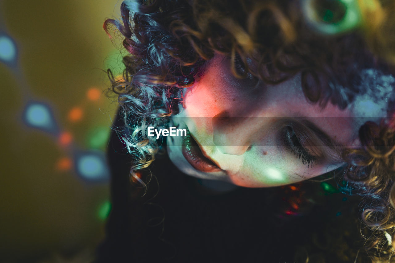 Close-up portrait of woman with multi colored lights