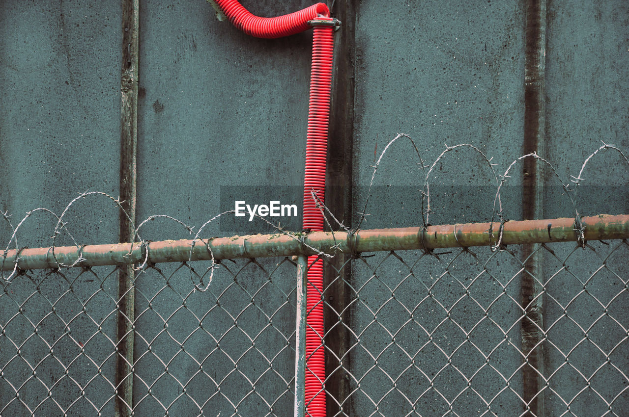 Close-up of chainlink fence against wall