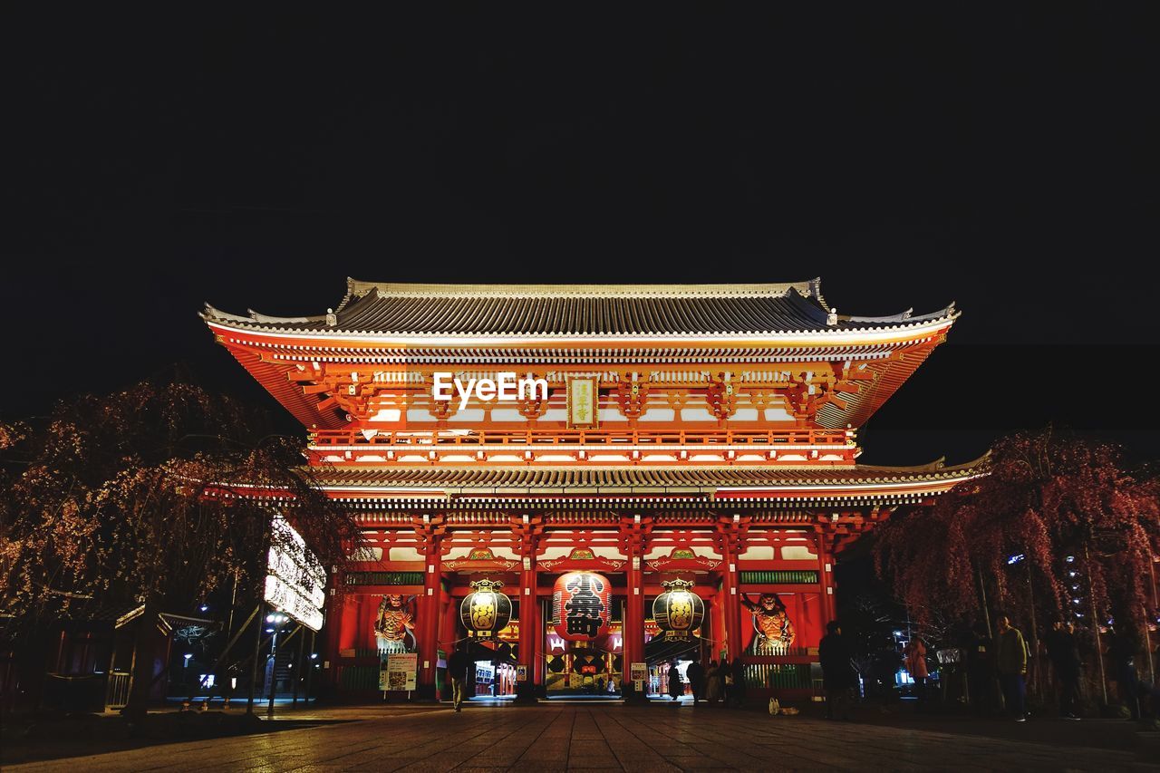 Low angle view of illuminated building against sky at night