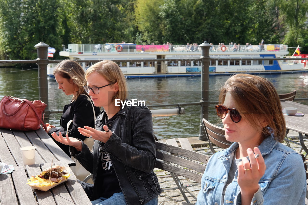 YOUNG WOMAN USING SMART PHONE BY LAKE