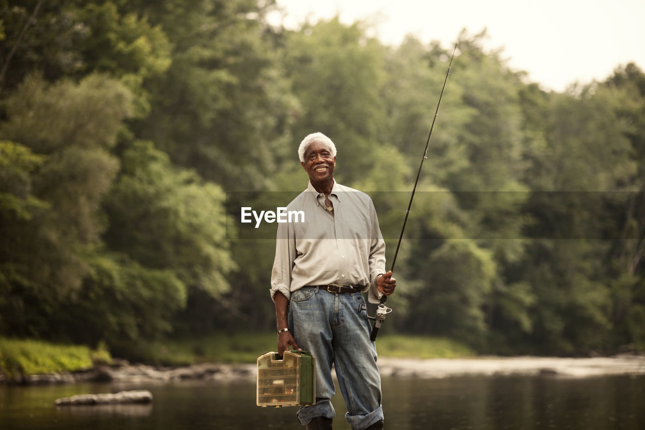 Portrait of man with fishing rod and basket