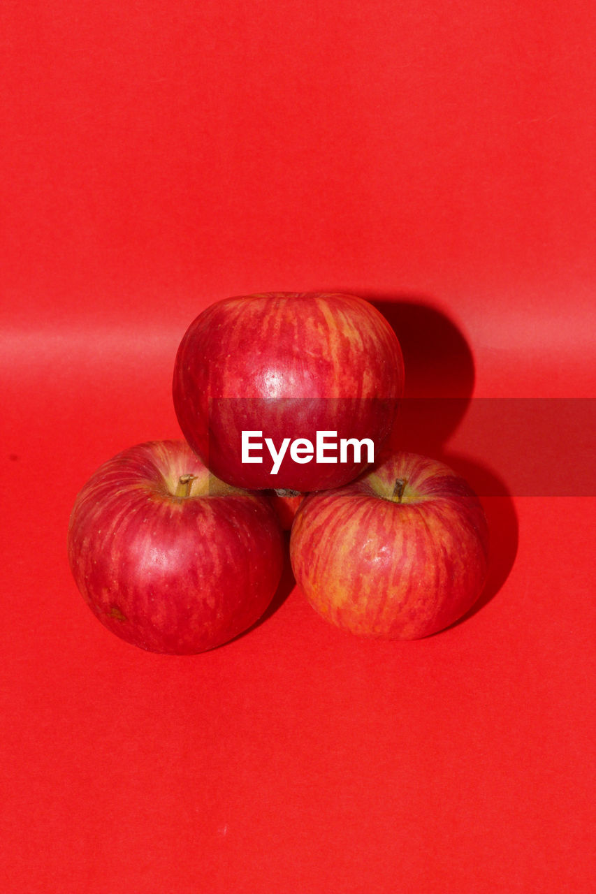 CLOSE-UP OF APPLES ON RED TABLE