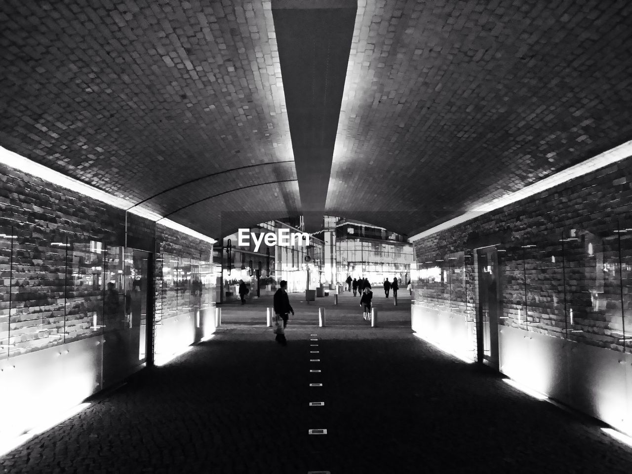 People in illuminated underground walkway