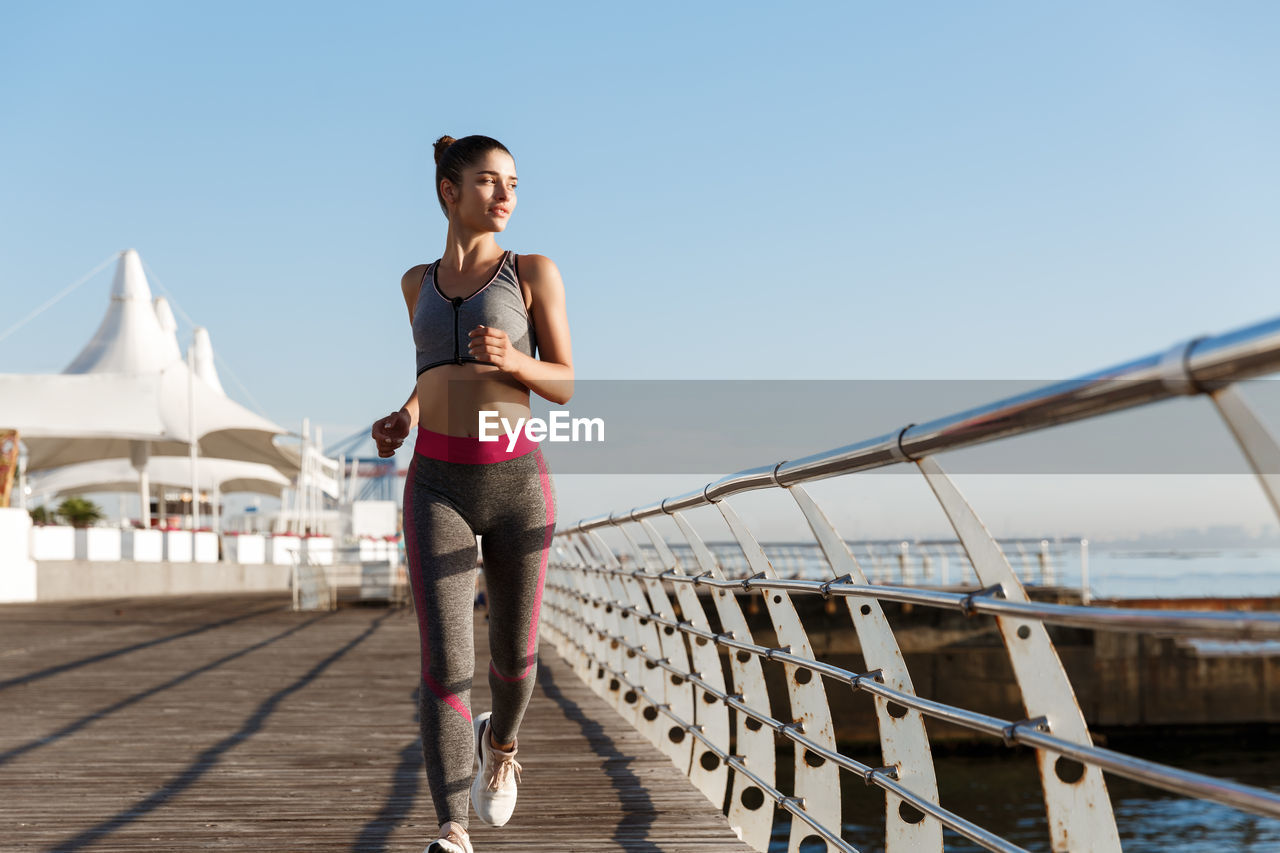 Full length of woman standing on bridge against sky