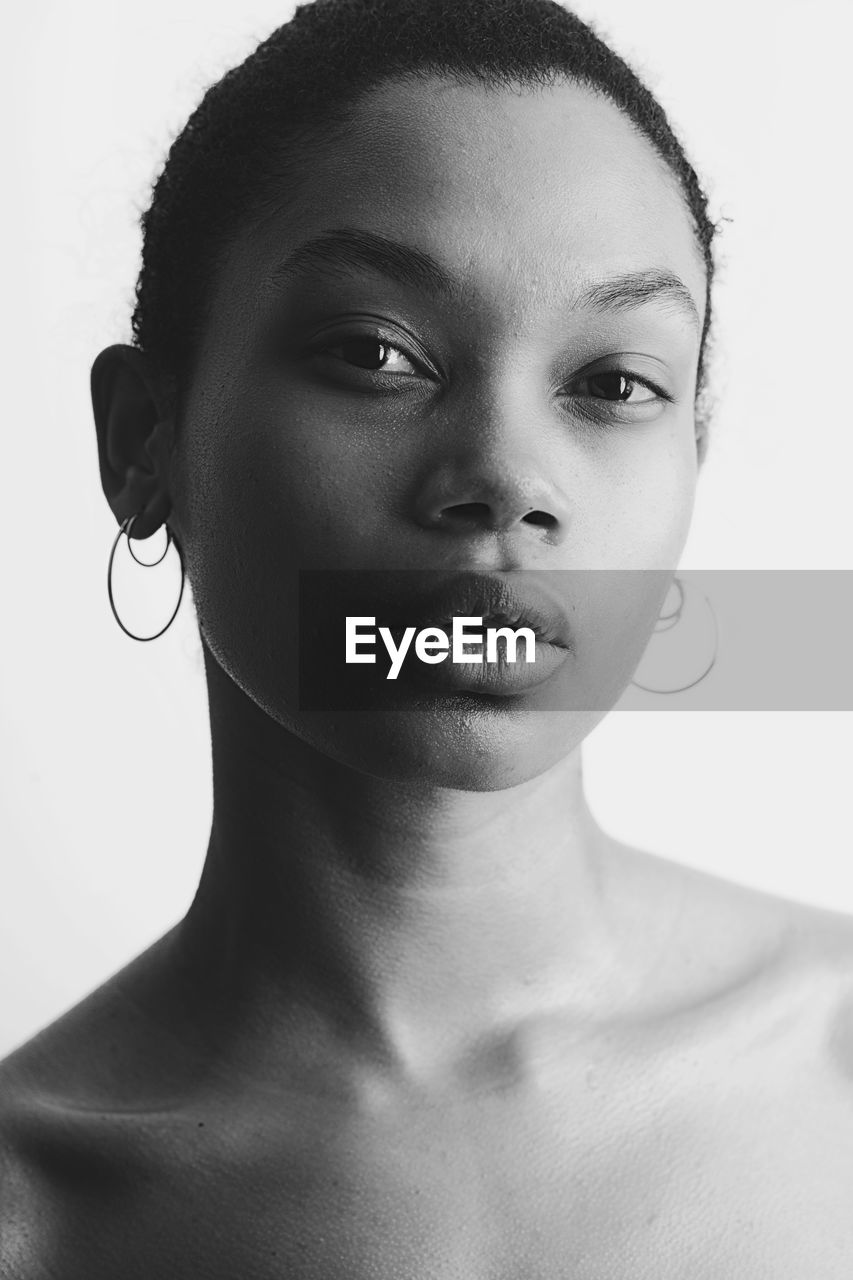 Close-up portrait of young woman over white background