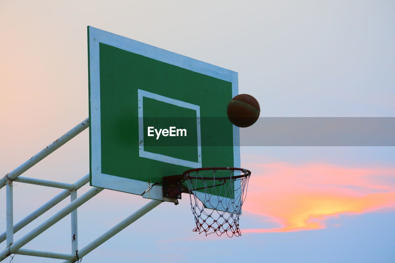 Low angle view of basketball hoop against sky during sunset