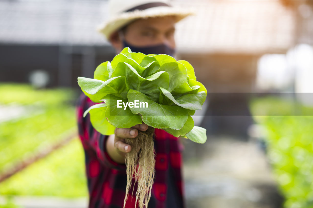 CLOSE-UP PORTRAIT OF WOMAN HOLDING LEAF