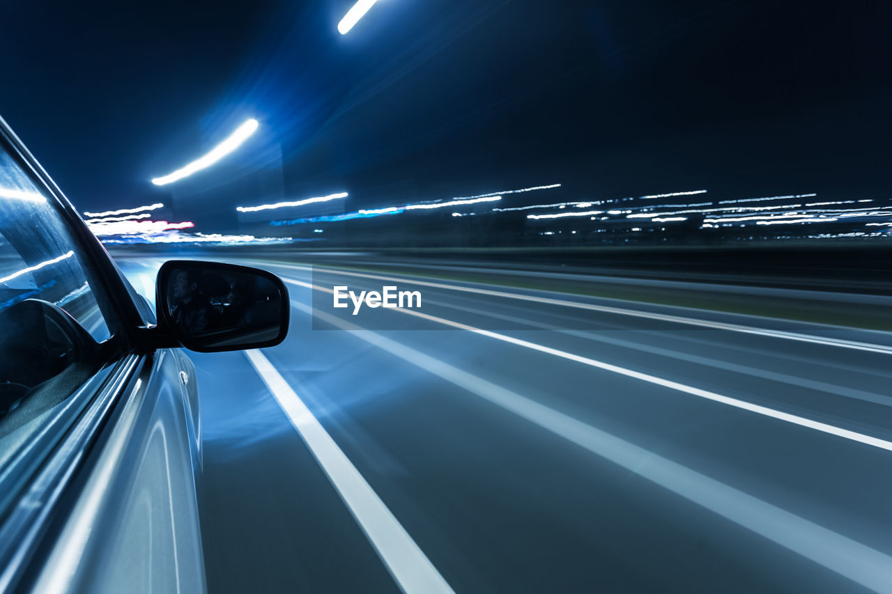 BLURRED MOTION OF CAR ON STREET AT NIGHT