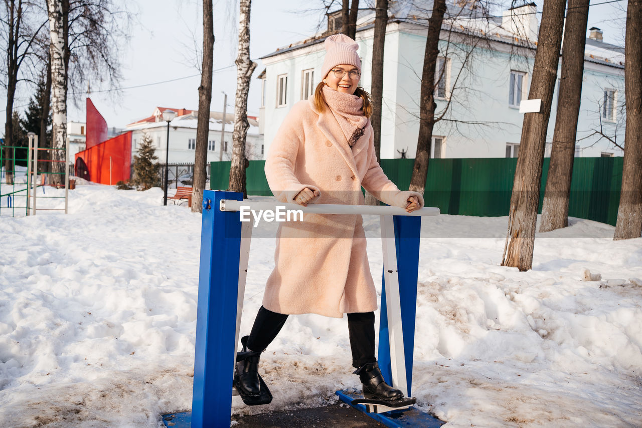 Woman on a simulator in the park goes in for sports on a sunny spring day