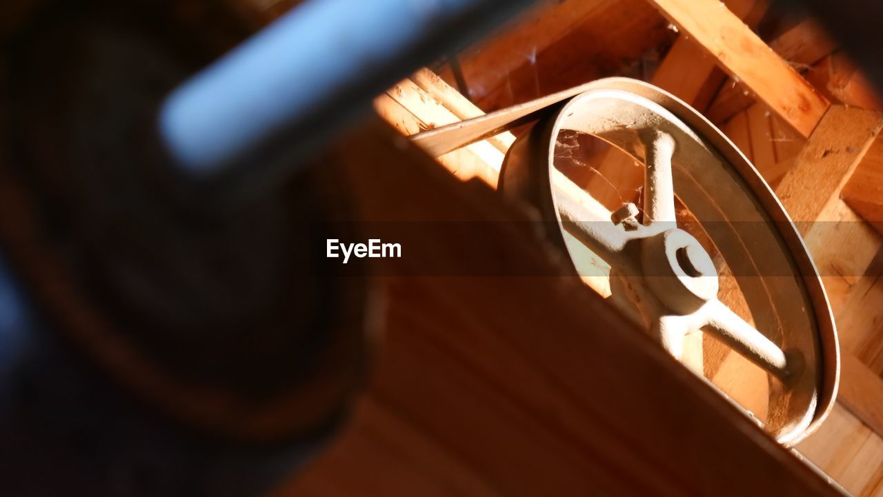 Low angle view of wheel hanging on wood