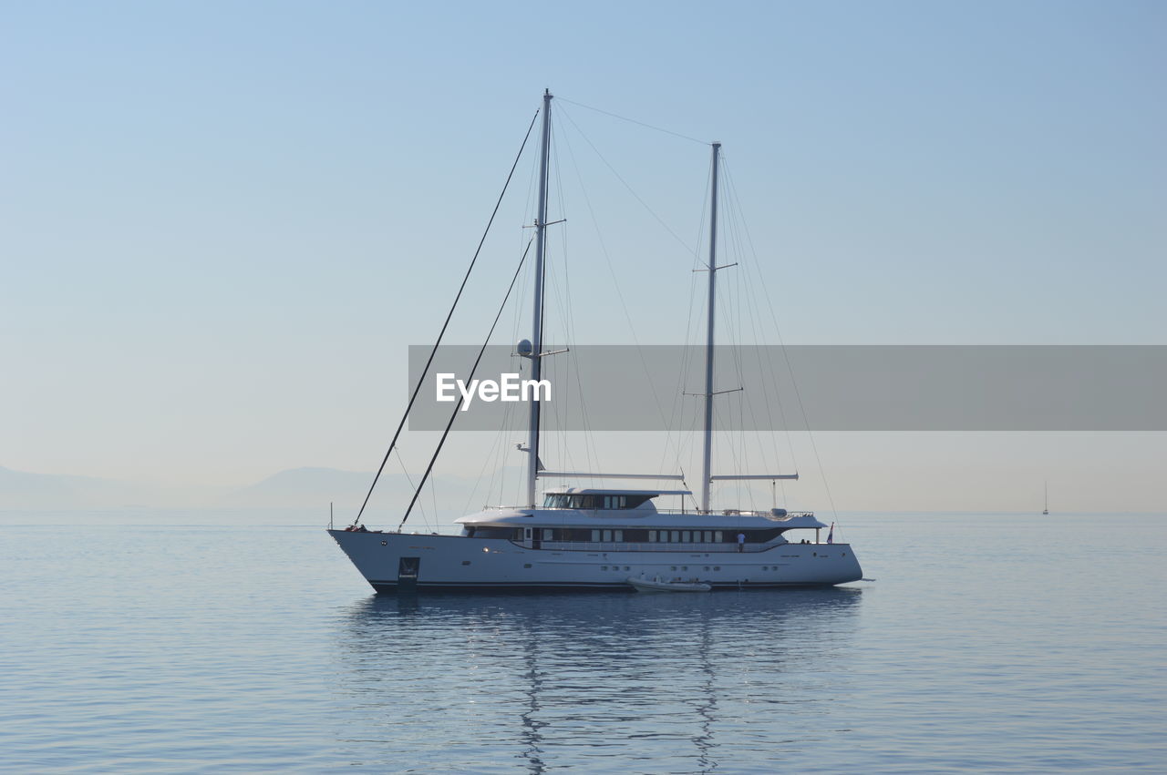 Sailboat sailing on sea against clear sky