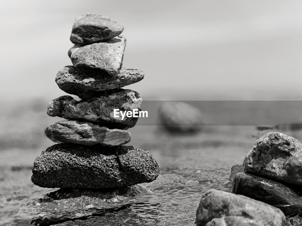 balance, rock, black and white, monochrome photography, monochrome, nature, stone, zen-like, no people, focus on foreground, land, day, beach, pebble, water, tranquility, sea, sky, outdoors, stability, close-up, tranquil scene, white, beauty in nature