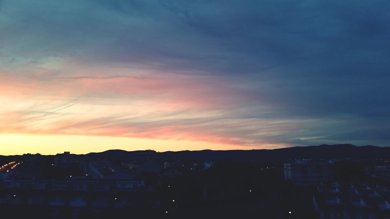 Town against sky during sunset