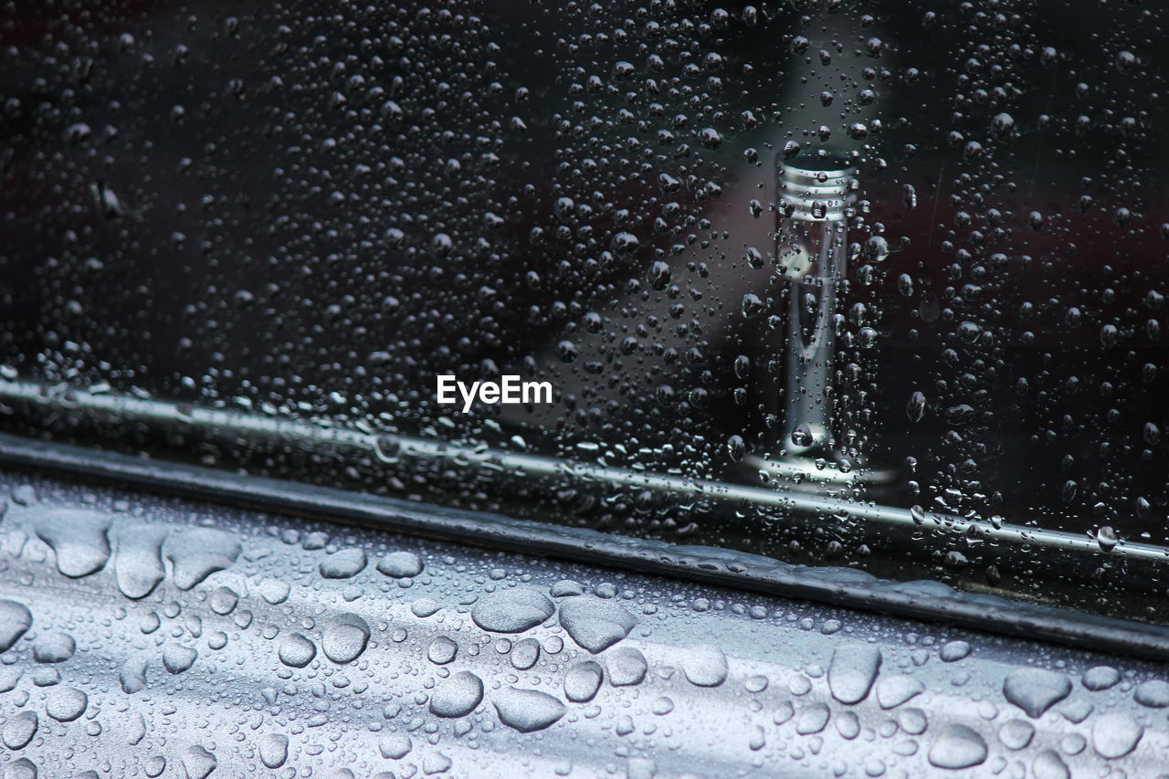 Close-up of wet car window during monsoon