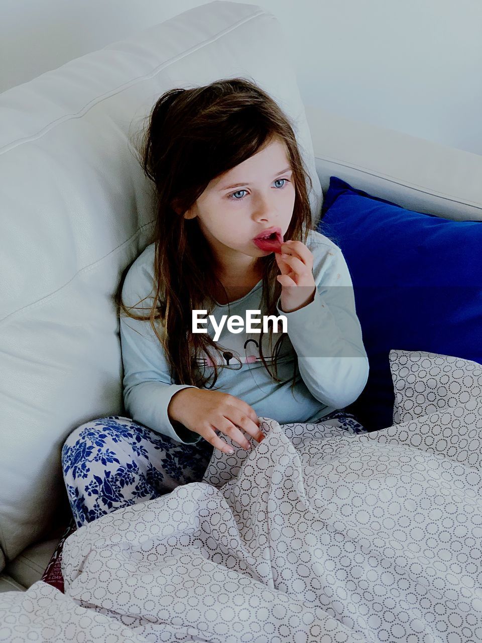 Cute girl sitting on sofa at home