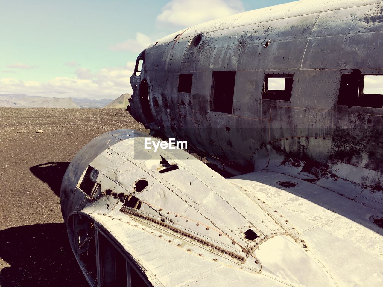 Abandoned airplane on landscape against sky