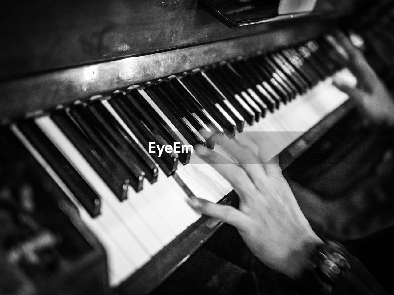 Cropped hands of person playing piano