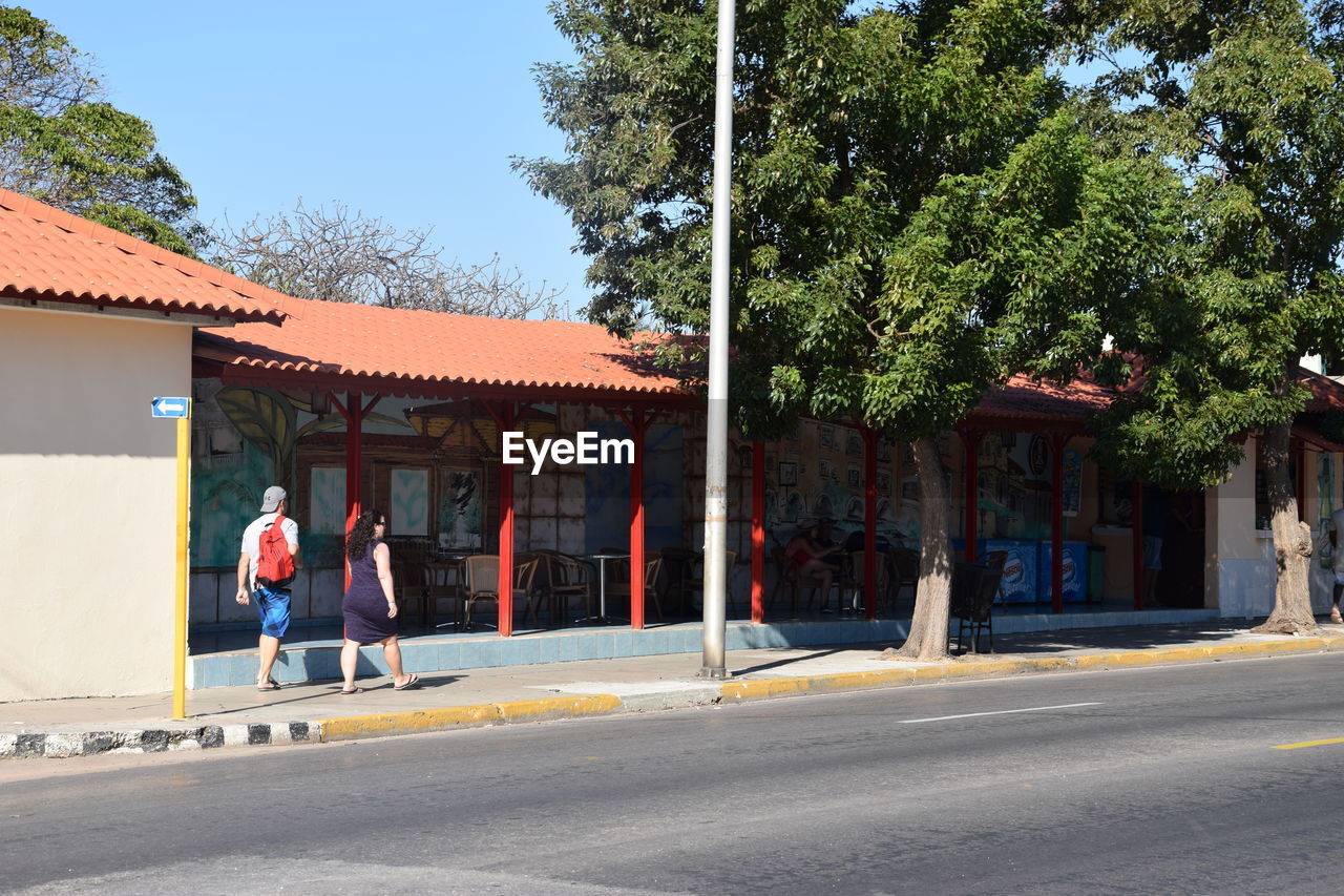 PEOPLE WALKING IN FRONT OF BUILDINGS