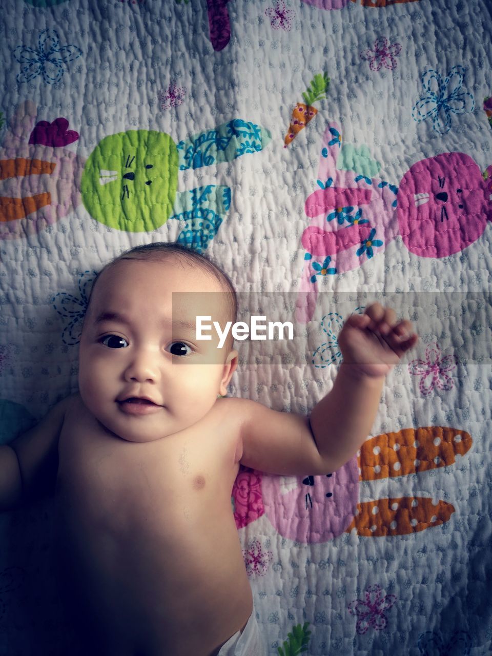 Portrait of cute baby girl on bed