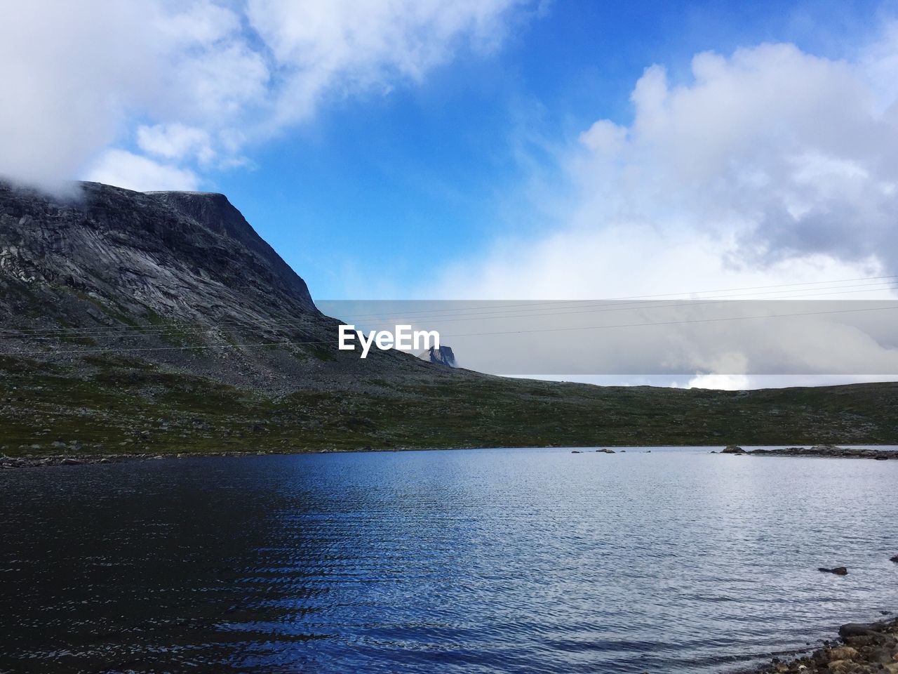 Scenic view of sea and mountain against sky