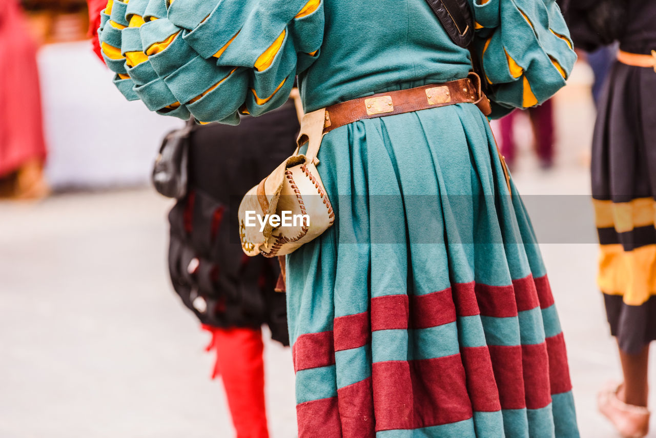 Midsection of man wearing traditional clothing on road during parade