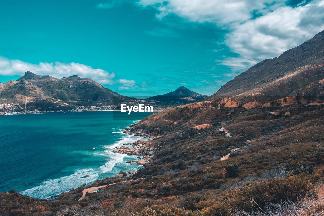 Scenic view of sea and mountains against sky