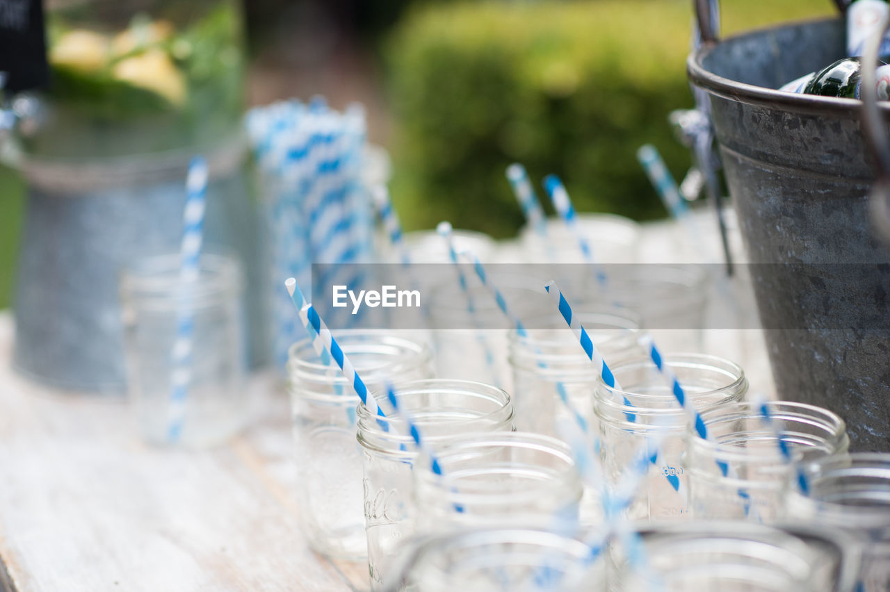 CLOSE-UP OF EMPTY GLASS WITH BOTTLE ON TABLE