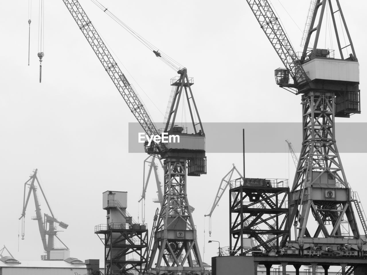 Low angle view of cranes against sky