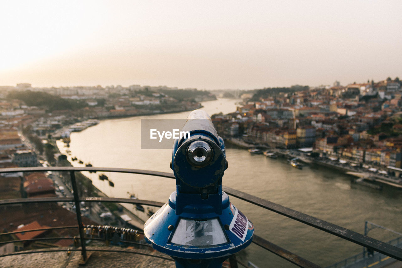 Coin-operated binoculars against clear sky during sunset