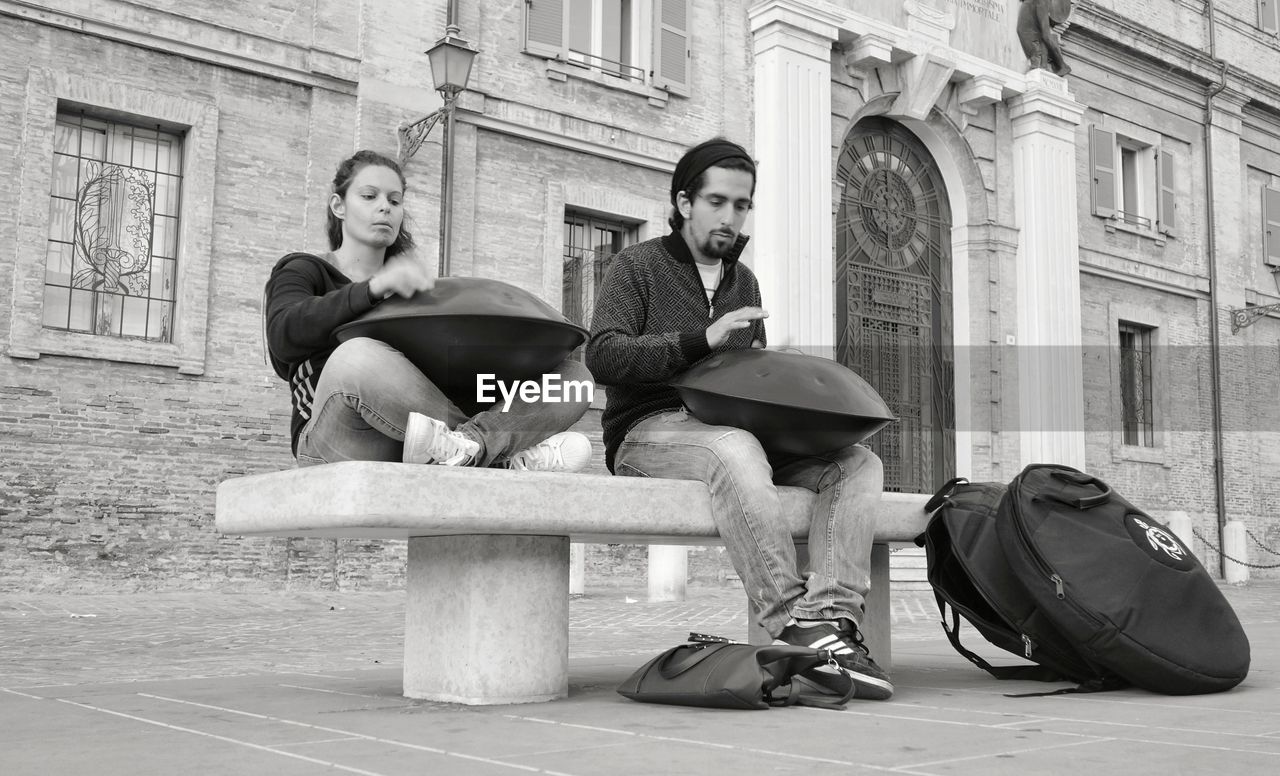 YOUNG COUPLE SITTING ON WALL