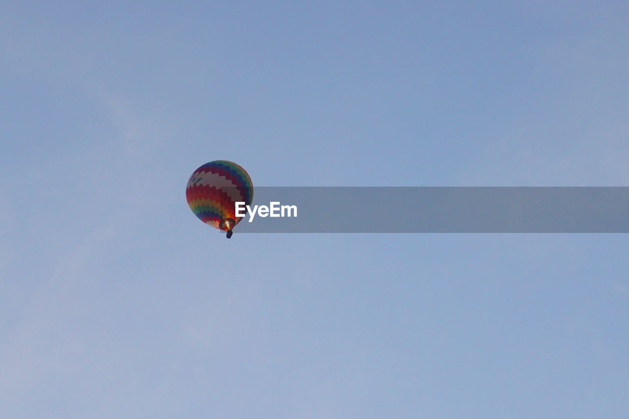 LOW ANGLE VIEW OF PARAGLIDING AGAINST CLEAR BLUE SKY