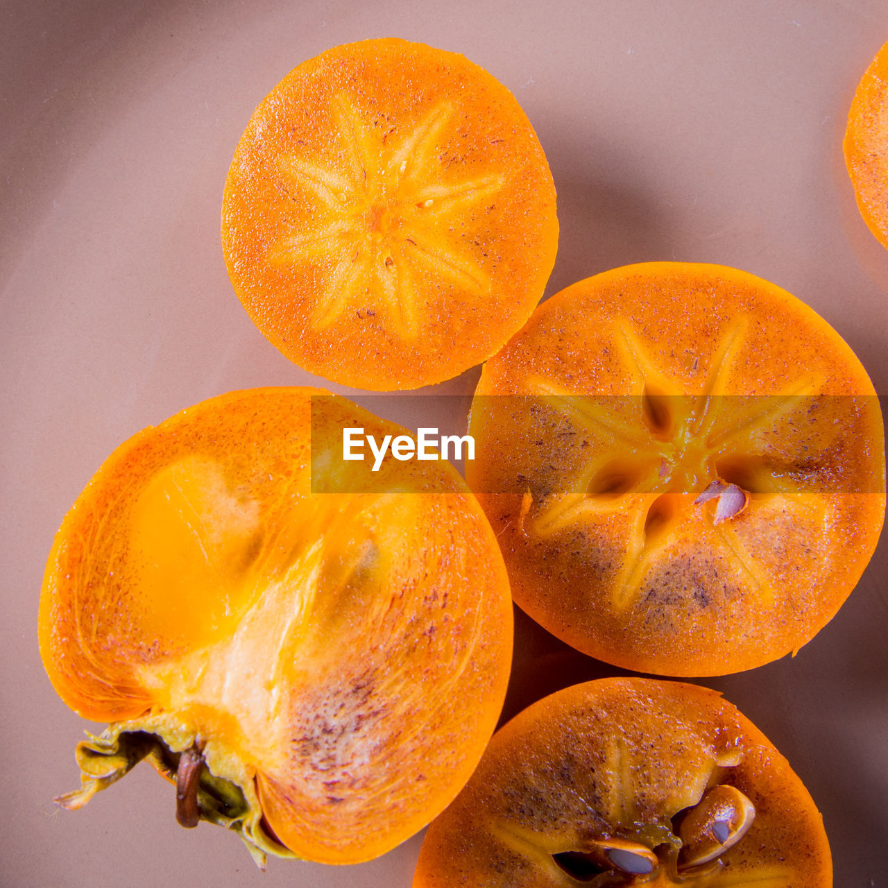 Persimmon cut into halves on a plate on a wooden table,copy space,closeup