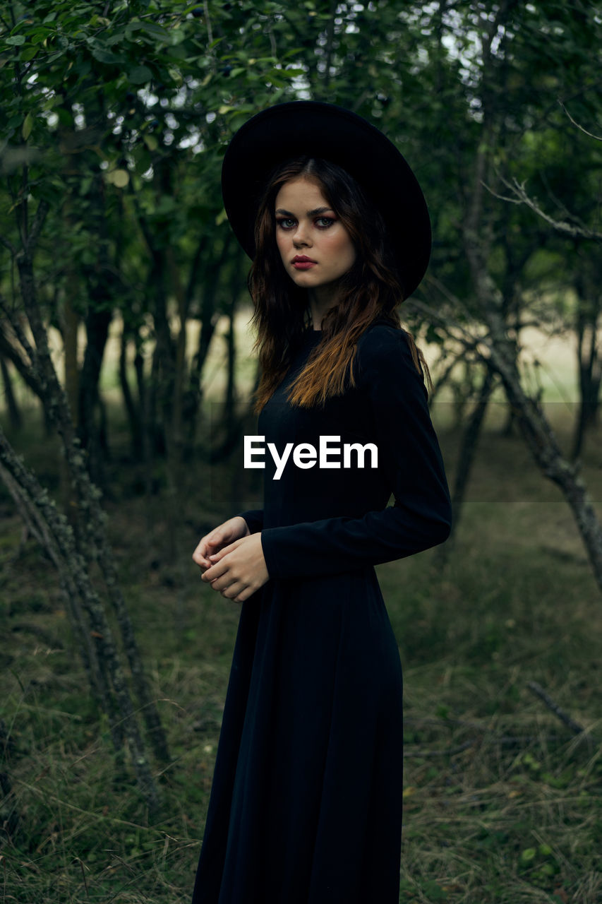 portrait of young woman standing in forest