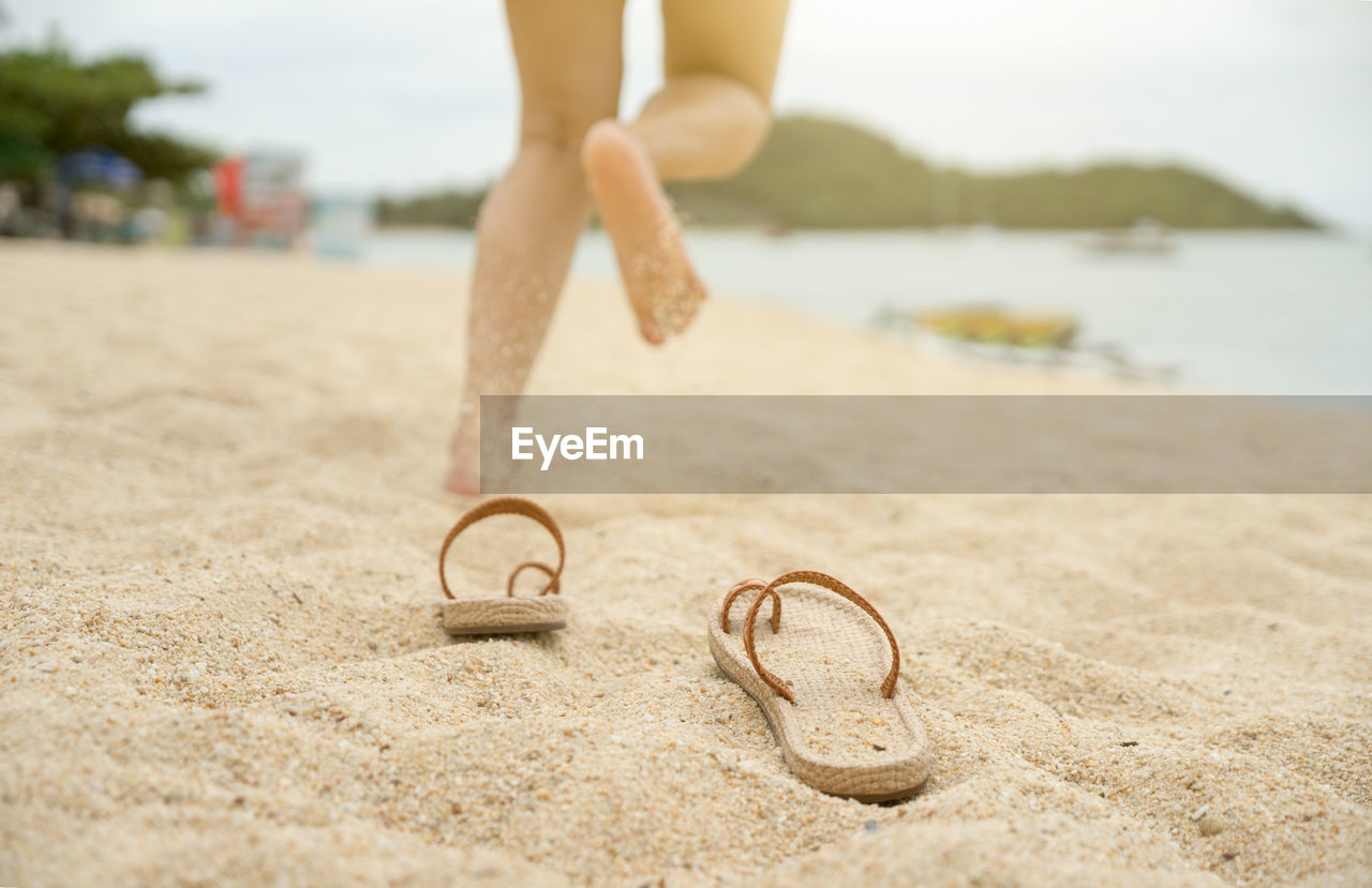 Low section of woman running on beach