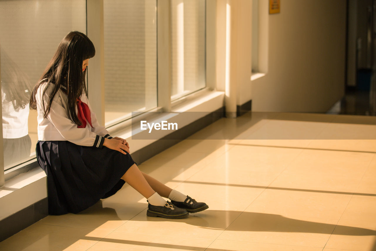 Schoolgirl sitting in corridor