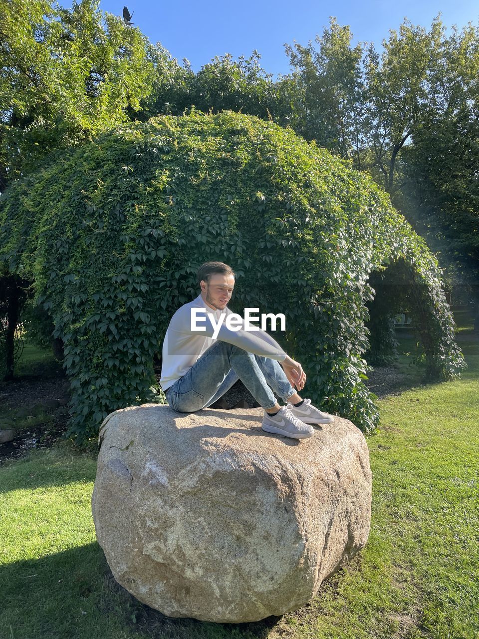 YOUNG WOMAN SITTING ON ROCK