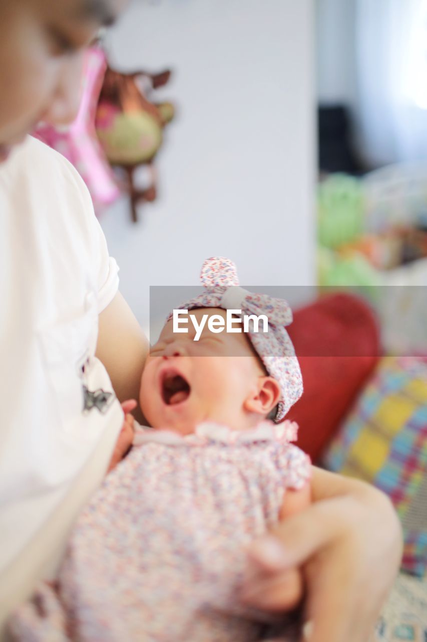 CUTE BABY GIRL LYING ON BED IN BEDROOM