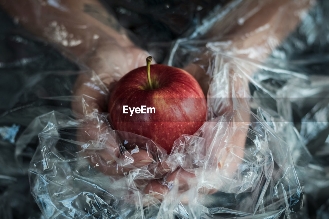 High angle view of red apple over plastic 