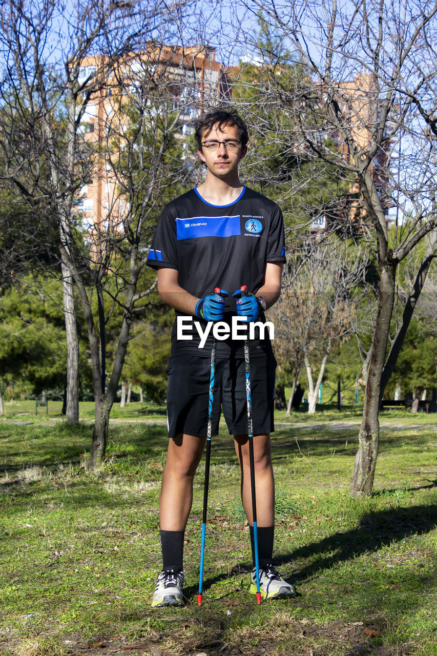 Nordic walking. young person practicing the sport nordic walking with poles in an outdoor park