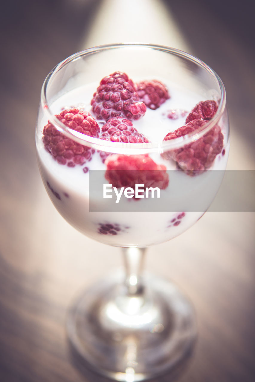 Close-up of fresh raspberries in milk glass