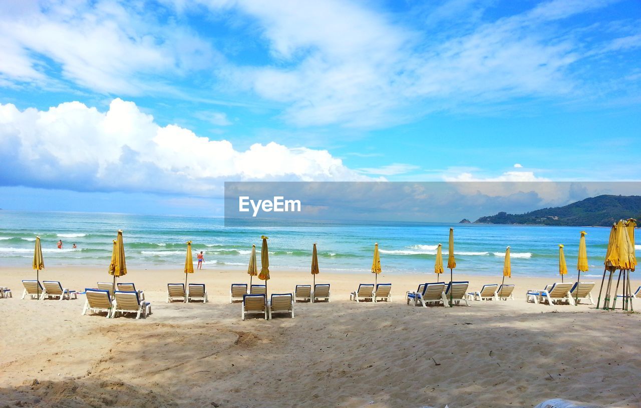 VIEW OF CHAIRS ON BEACH AGAINST SKY