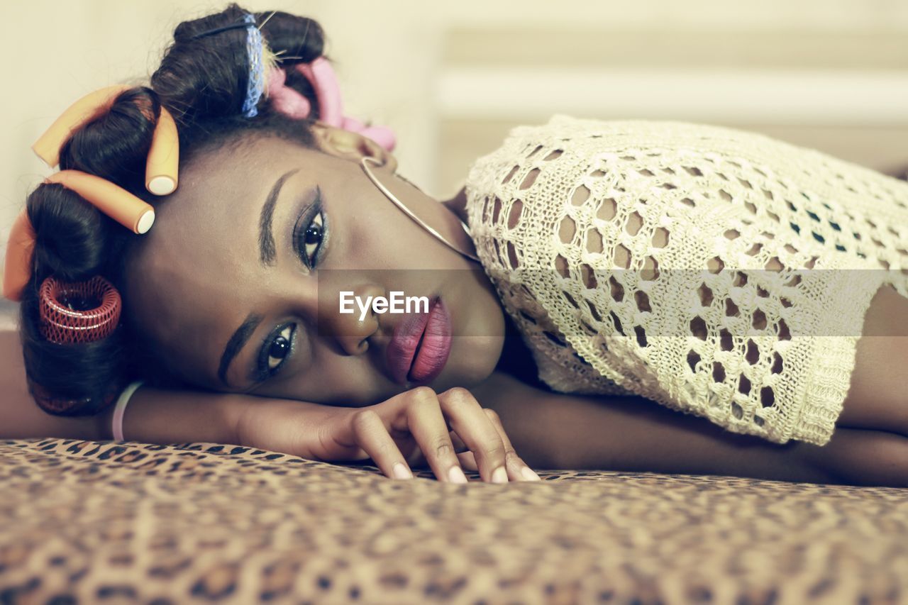 Portrait of young woman lying on bed