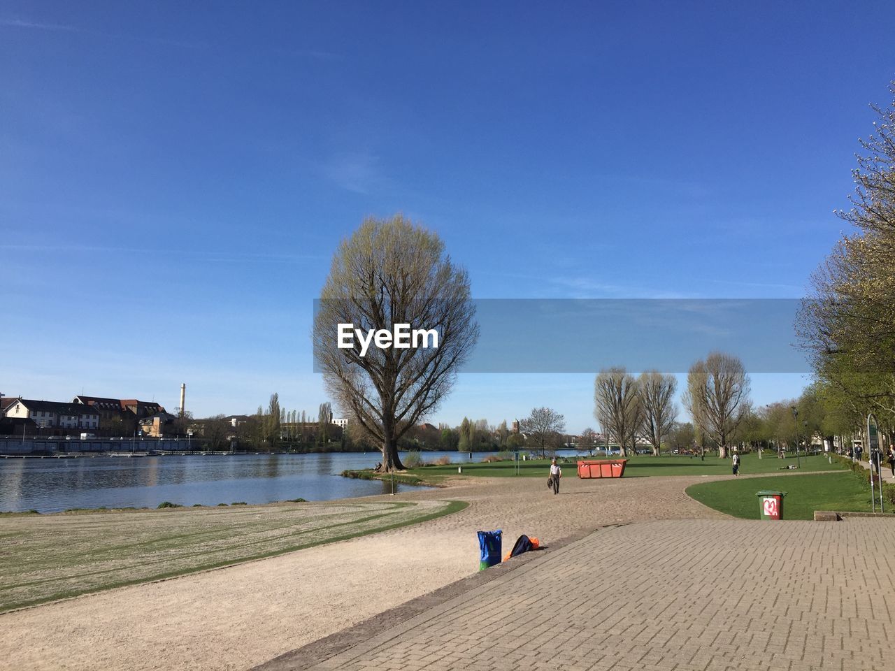 PARK BY LAKE AGAINST BLUE SKY