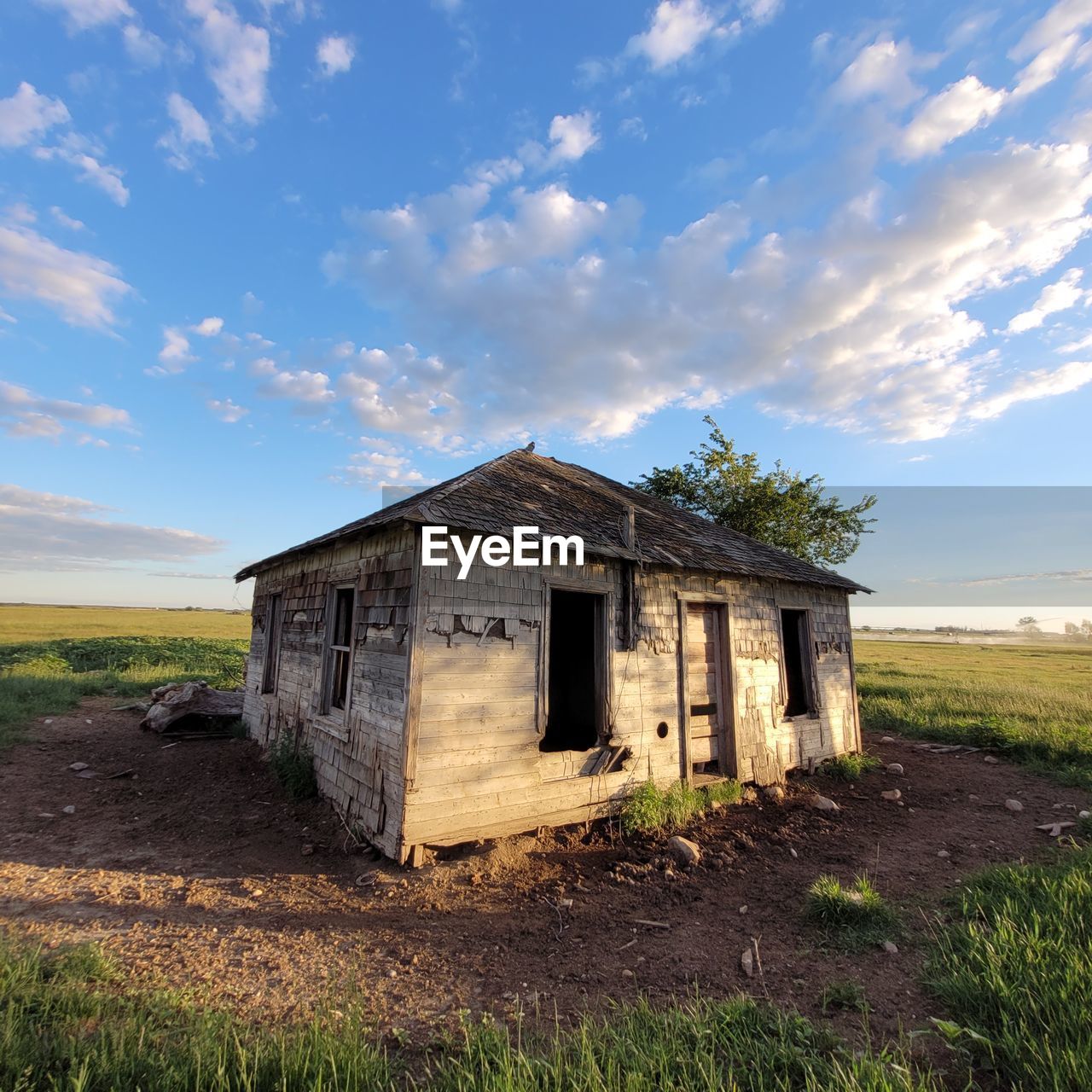 ABANDONED BUILDING ON FIELD AGAINST SKY