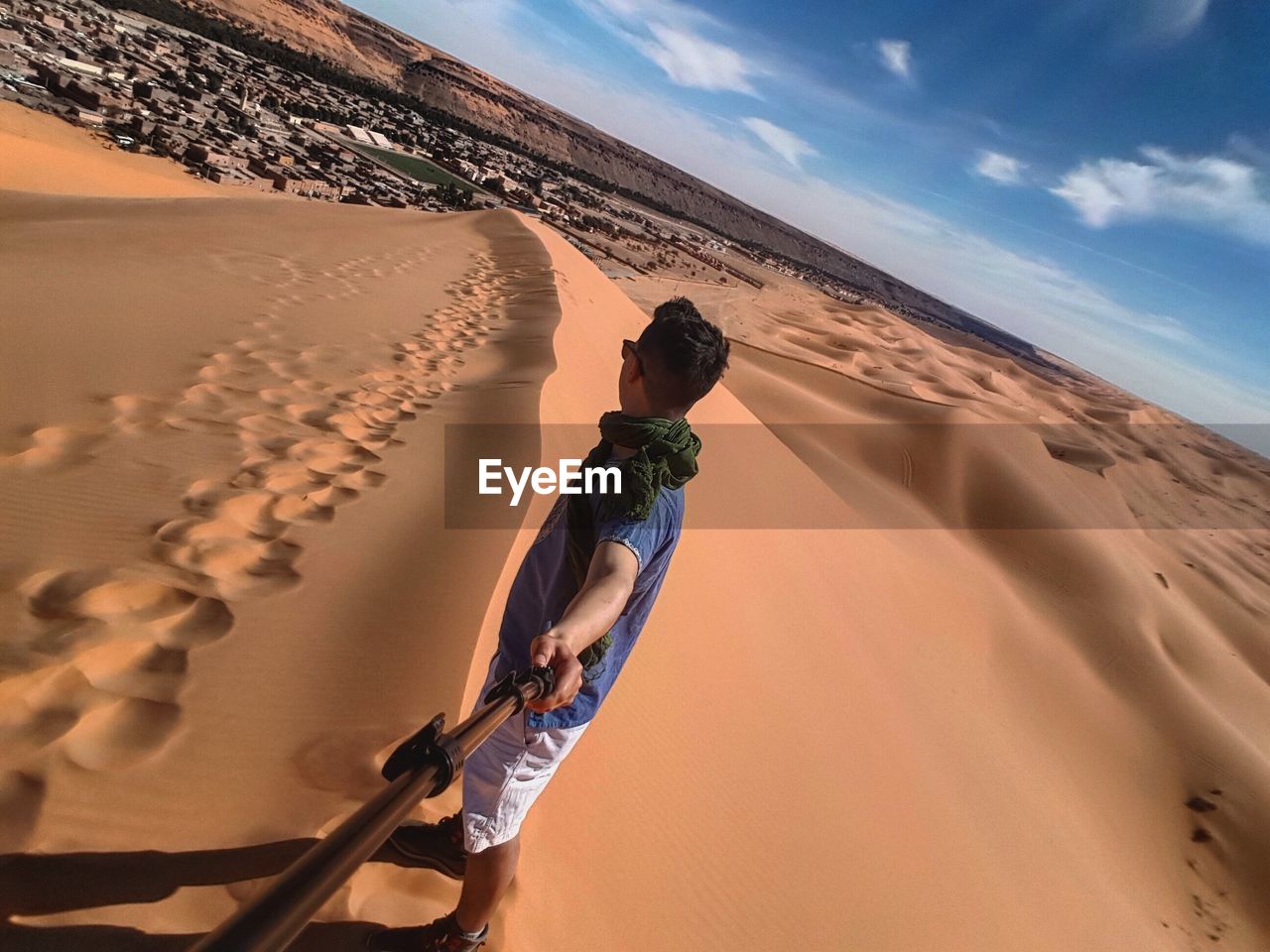 Man on sand at desert against sky