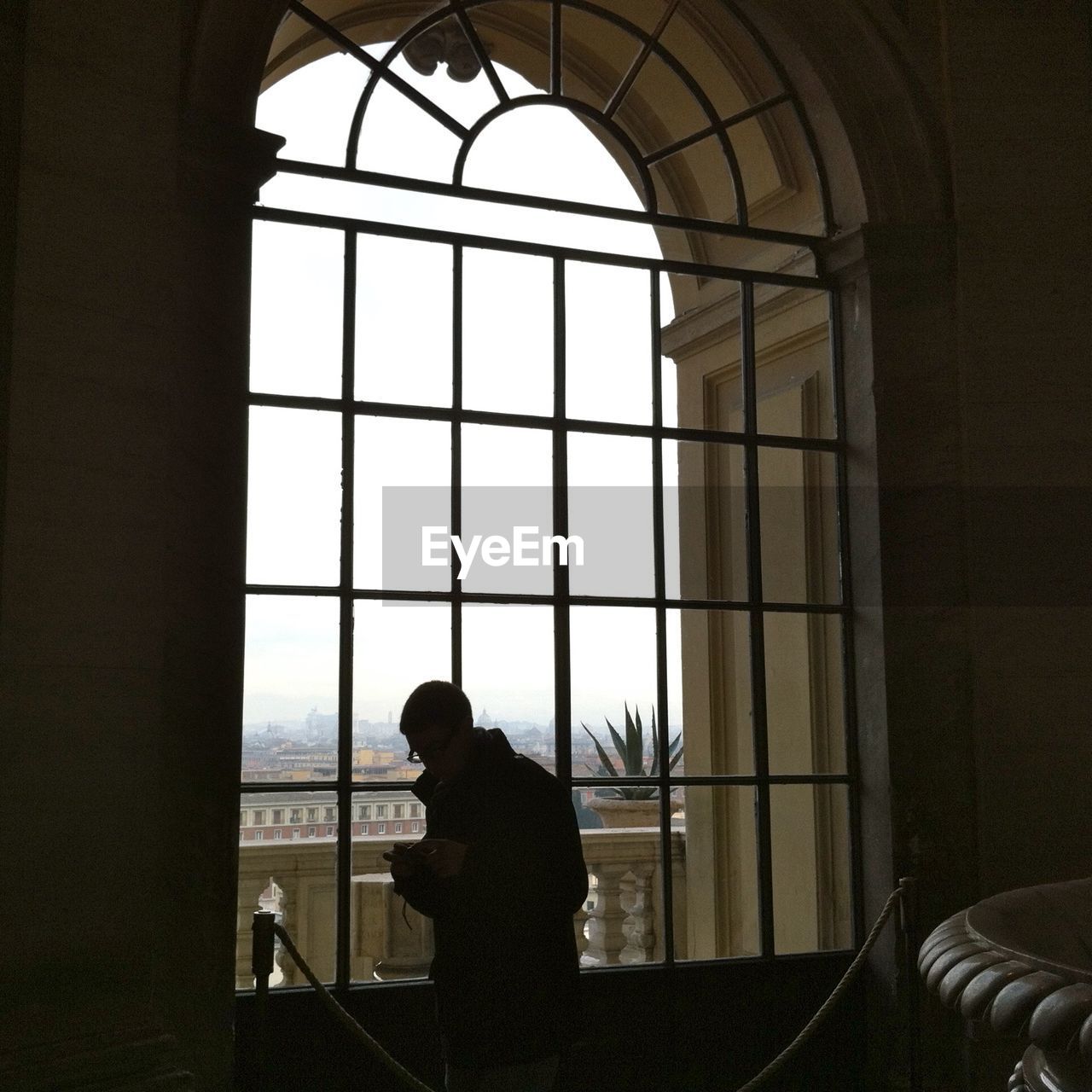 LOW ANGLE VIEW OF WOMAN STANDING ON RAILING