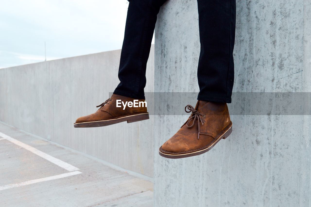 Low section of man dangling against wall