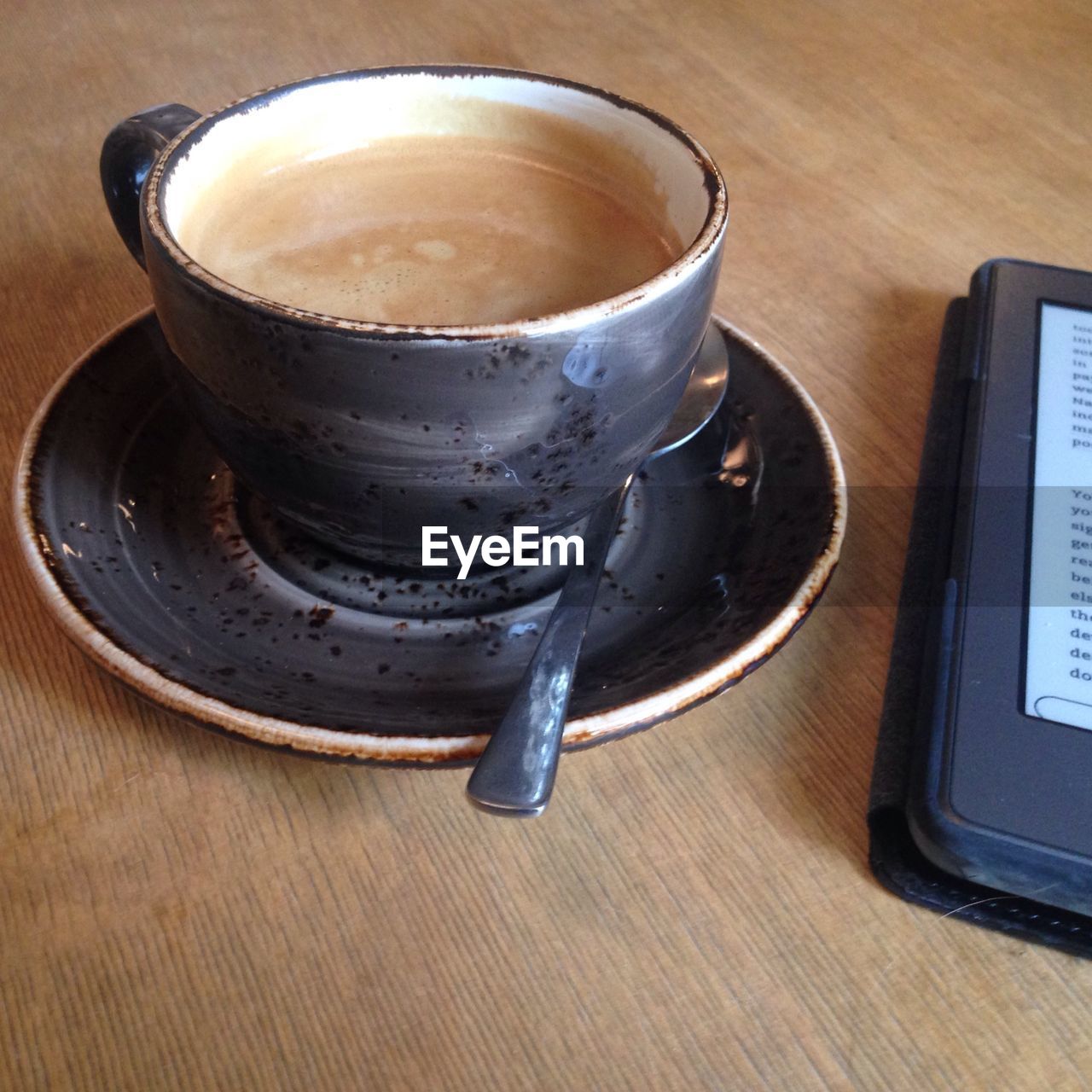 High angle view of coffee and smart phone on wooden table