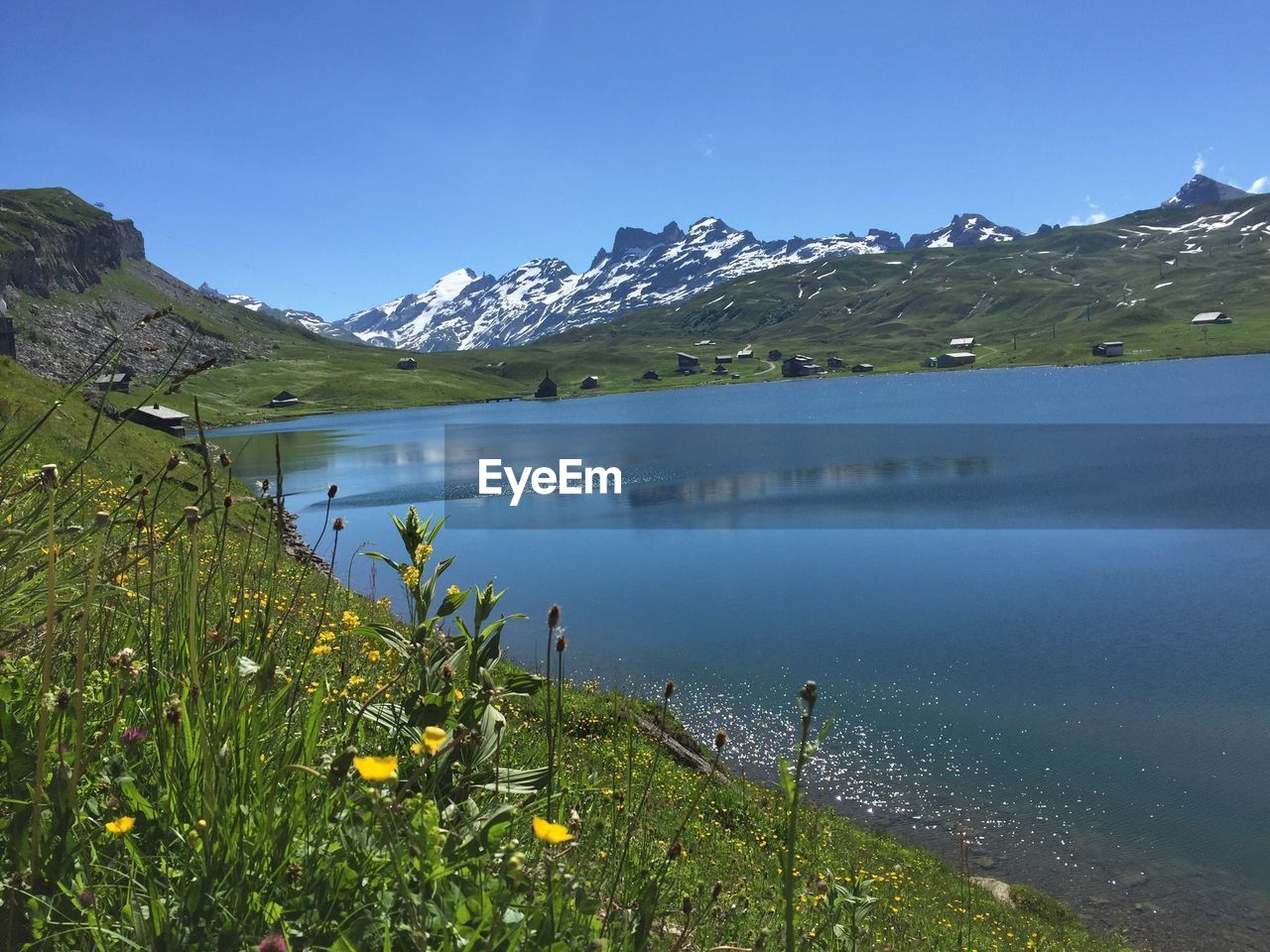 Scenic view of lake by mountains against sky